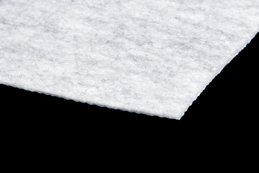Zbliżenie na grubą strukturę włókniny Anti-Drop 200 Sound Absorbing tłumiącej hałas deszczu i gradu.